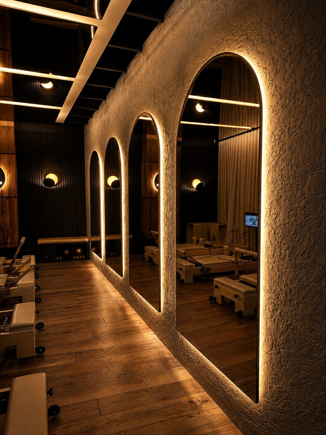 Arched backlit mirrors in the KB Pilates reformer studio, Glebe